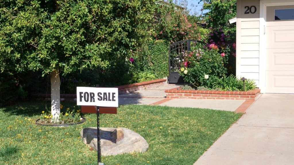 Cartel de se vende en el jardín de una vivienda