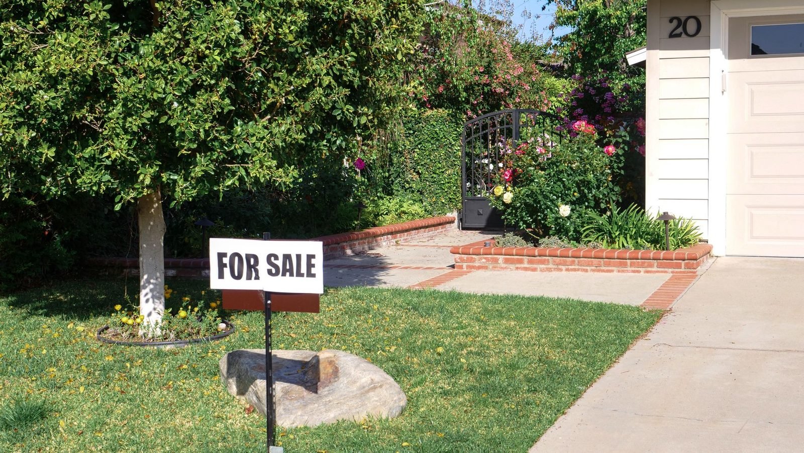 Cartel de se vende en el jardín de una vivienda