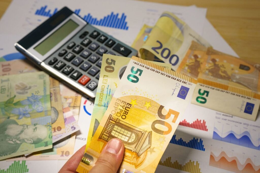 Calculadora y billetes para calcular la plusvalía municipal al vender una vivienda