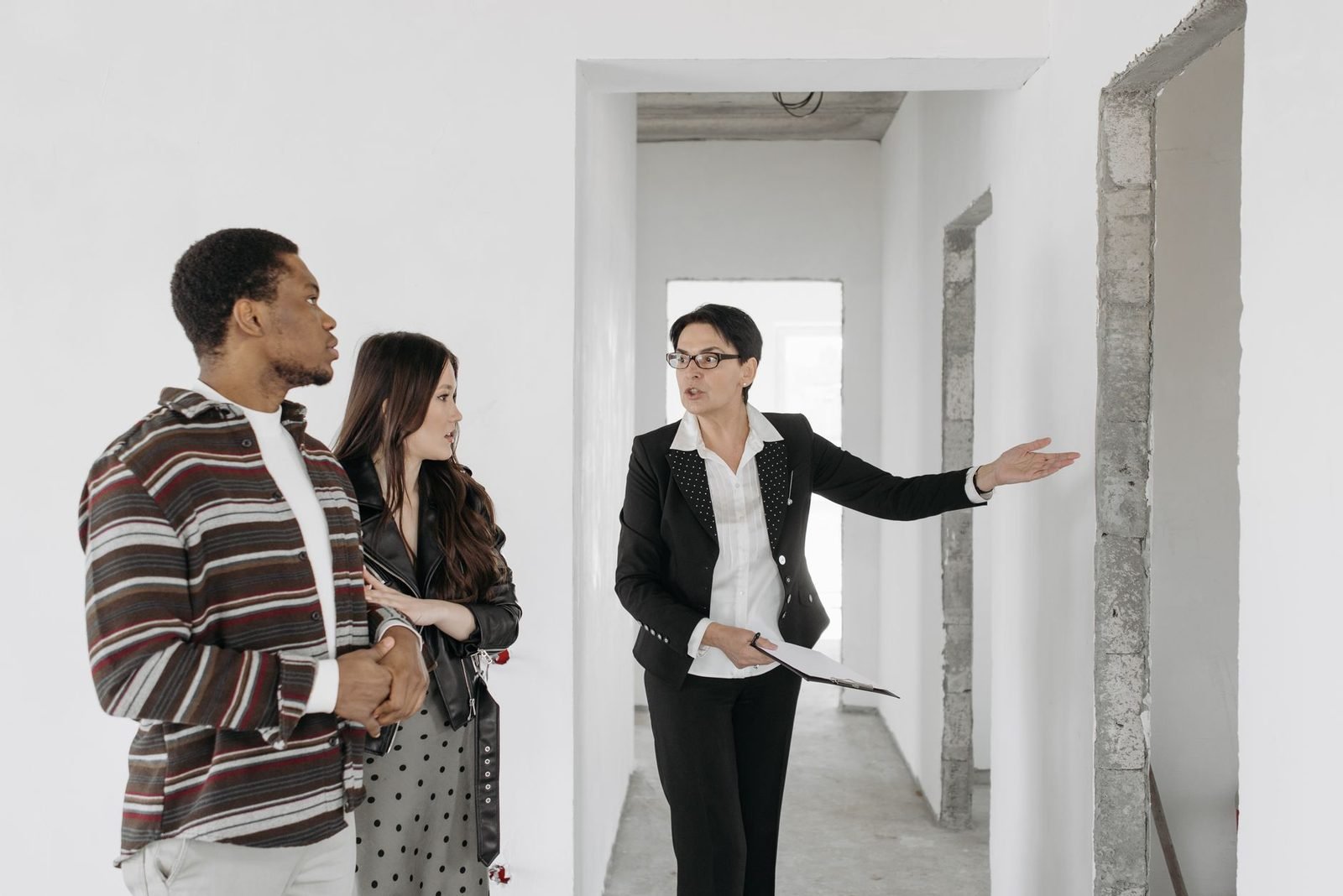 Pareja visitando un piso en venta acompañada de un agente inmobiliario